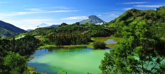 Tropische Landschaft mit blaugrünem See und Bergen nahe der Udayana University auf Bali.