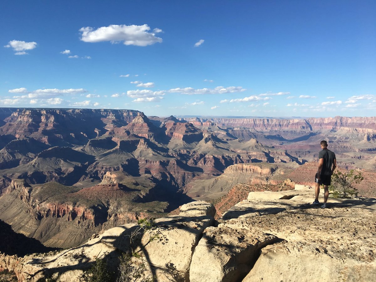 Mann steht am Rand des Grand Canyon und blickt in die Ferne